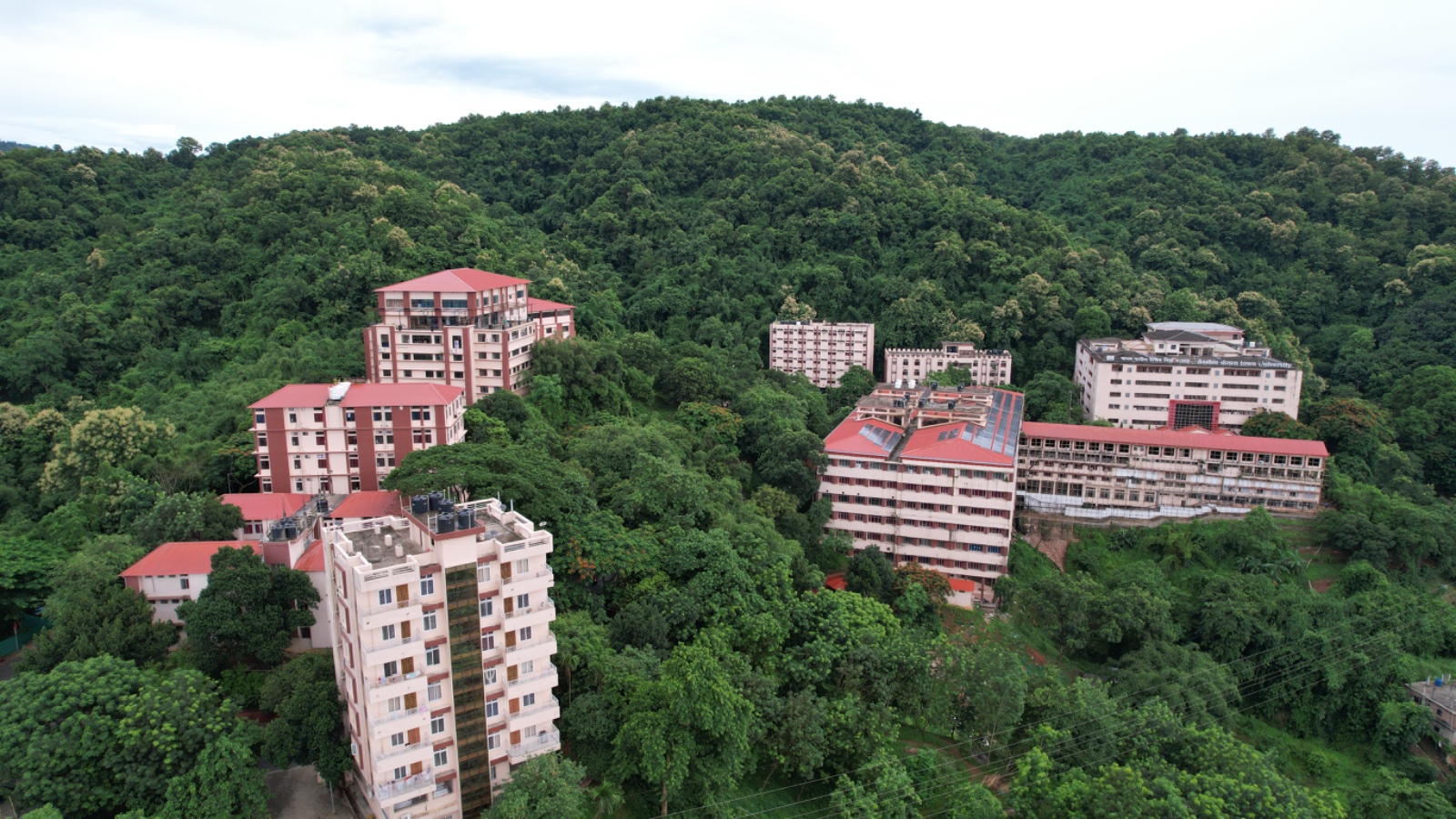 Aerial view of Assam Down Town University campus among green hills